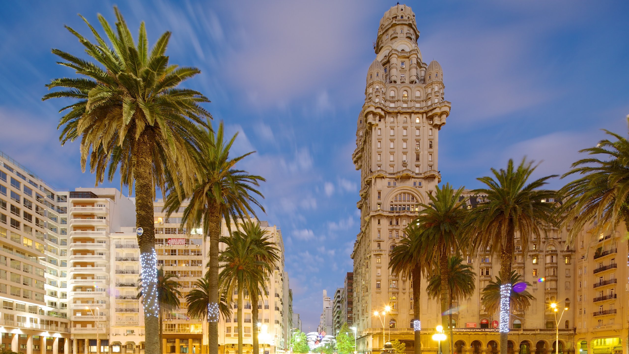 Palacio Salvo que incluye escenas cotidianas, un atardecer y una ciudad