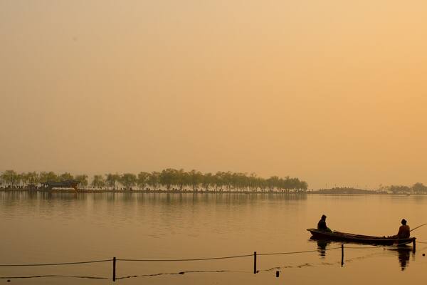 Broken Bridge which includes a sunset, a lake or waterhole and kayaking or canoeing