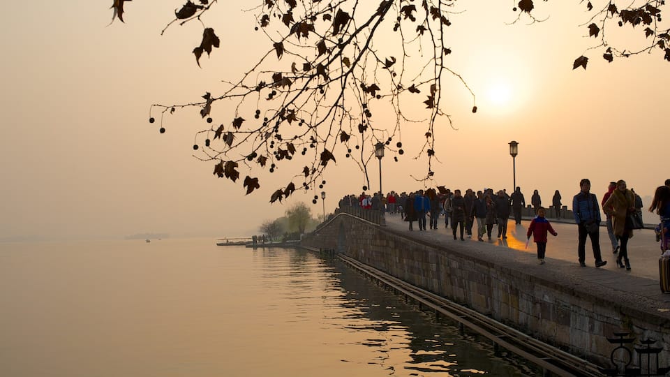Broken Bridge featuring a sunset and a bridge as well as a large group of people