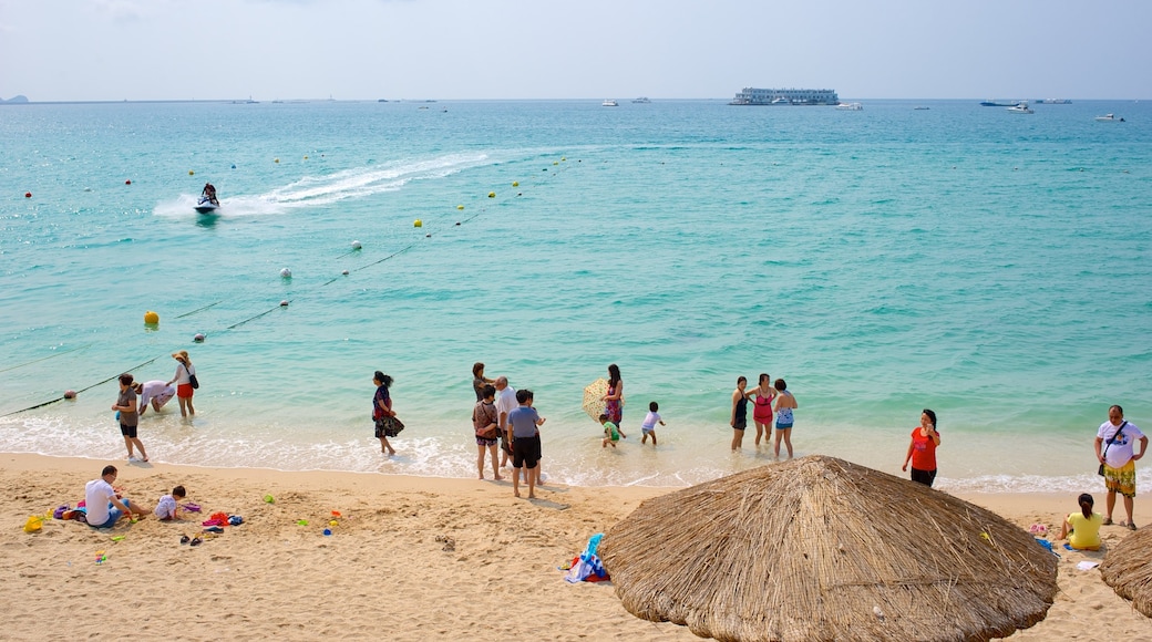 Dadonghai-strand toont een zandstrand en algemene kustgezichten en ook een grote groep mensen