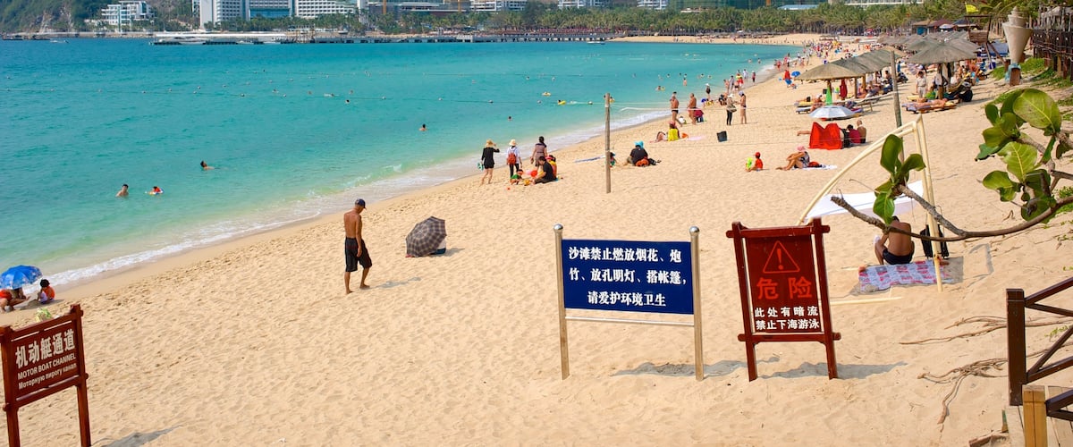 Playa Dadongdai que incluye una playa de arena, señalización y una ciudad costera
