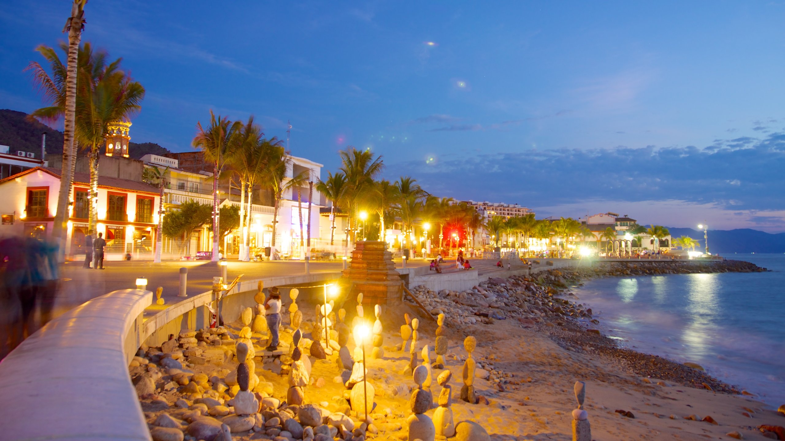 Malecon showing night scenes, a coastal town and a sandy beach