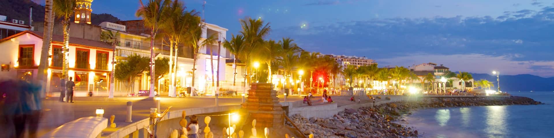 Malecon showing night scenes, a coastal town and a sandy beach