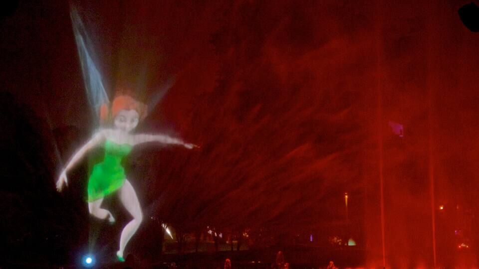 Parque da Exposição que inclui cenas noturnas, uma fonte e arte ao ar livre