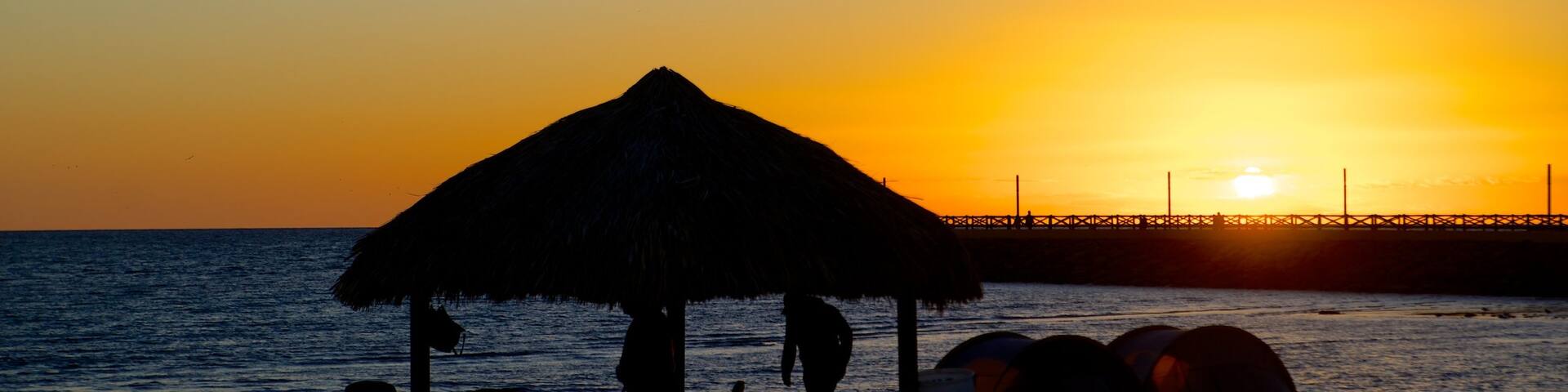 Playa Miramar which includes tropical scenes, a sunset and general coastal views