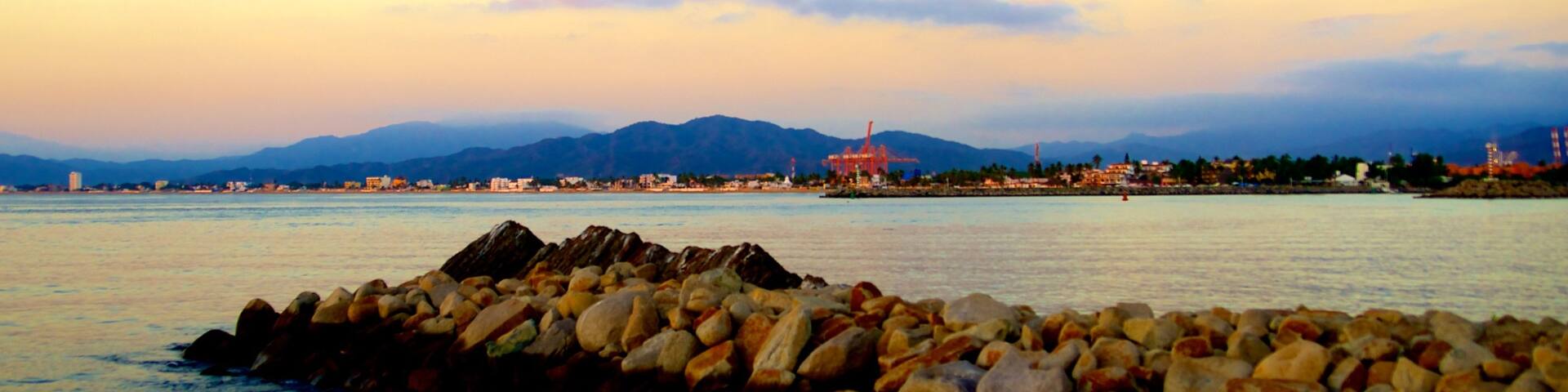 Playa San Pedrito welches beinhaltet Sonnenuntergang, allgemeine KĂŒstenansicht und schroffe KĂŒste