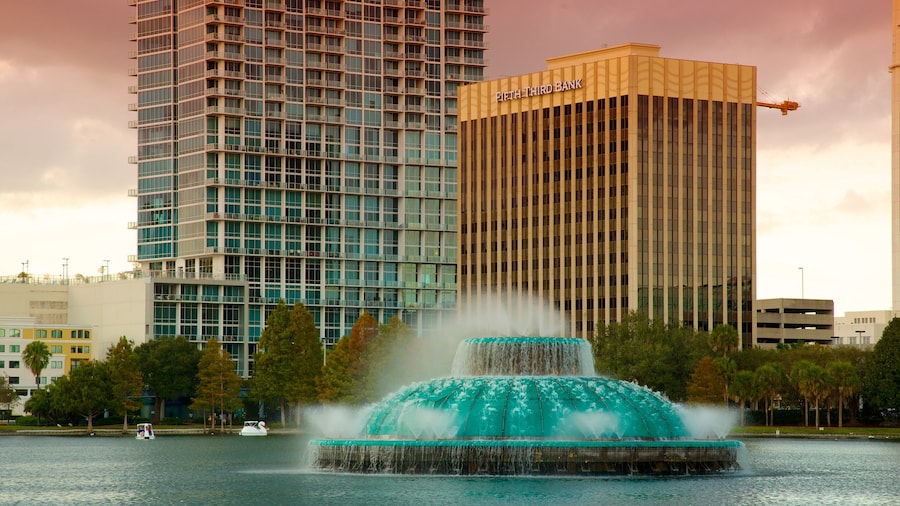 Lake Eola Park som inkluderar en stad, en solnedgång och en sjö eller ett vattenhål
