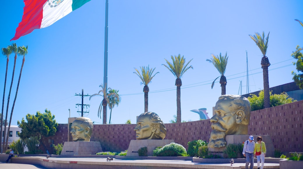 Ensenada mostrando una estatua o escultura y arte al aire libre y también una pareja