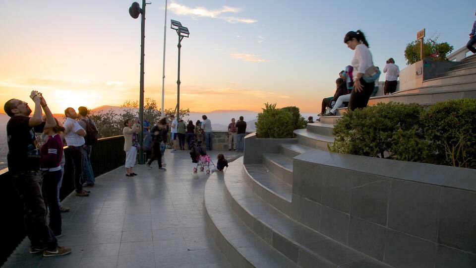 San Cristobal Hill featuring views and a sunset as well as a large group of people