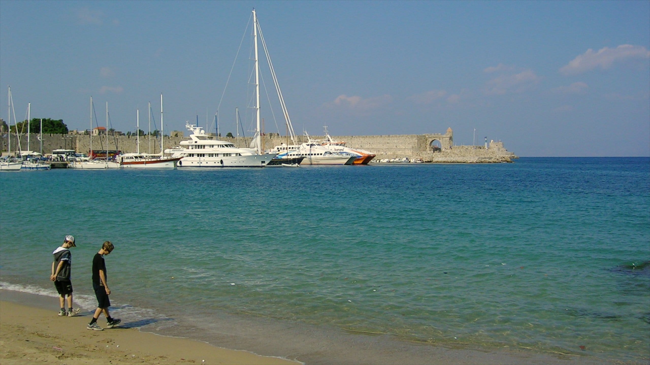 Rhodes which includes a bay or harbor, a sandy beach and boating