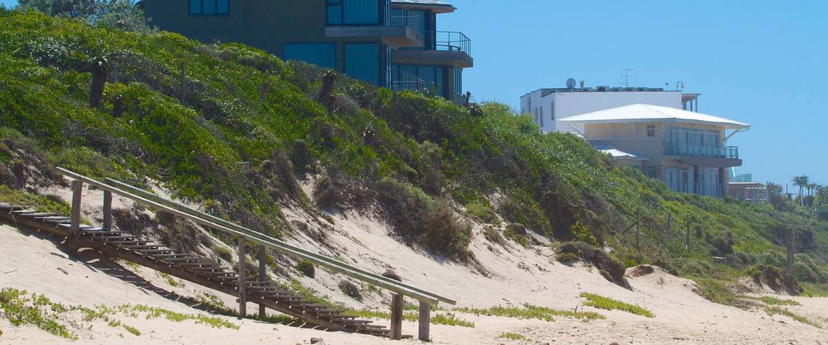 Dolphin Beach showing a coastal town, a house and a sandy beach