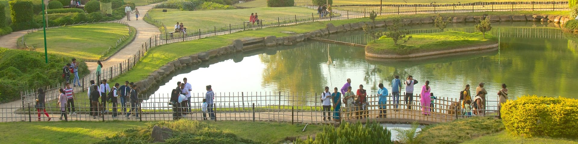 Pune featuring a pond and a garden as well as a large group of people