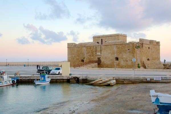 Pafos hamn som visar en hamn eller havsbukt och en solnedgÄng
