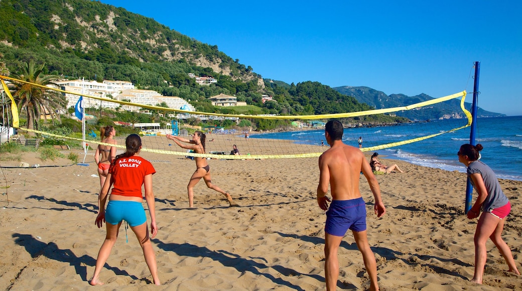 Playa de Pelekas ofreciendo una playa de arena y una localidad costera y también un grupo pequeño de personas