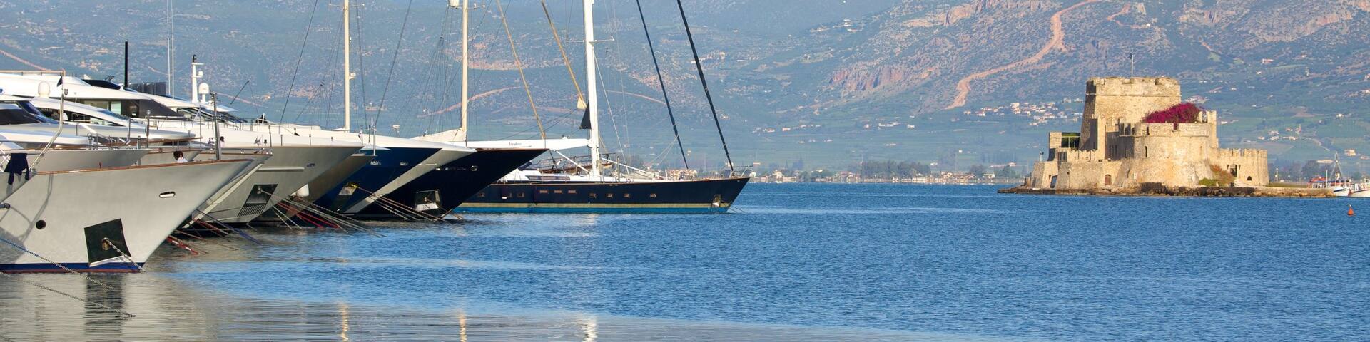 Castle of Bourtzi featuring a bay or harbor, sailing and mountains