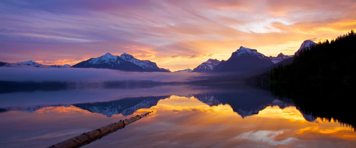 Parque Nacional de Glacier caracterizando um lago ou charco e um pôr do sol