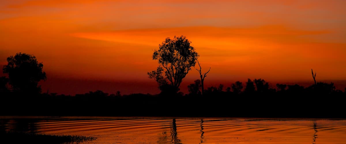 Kakadu National Park which includes a lake or waterhole and a sunset