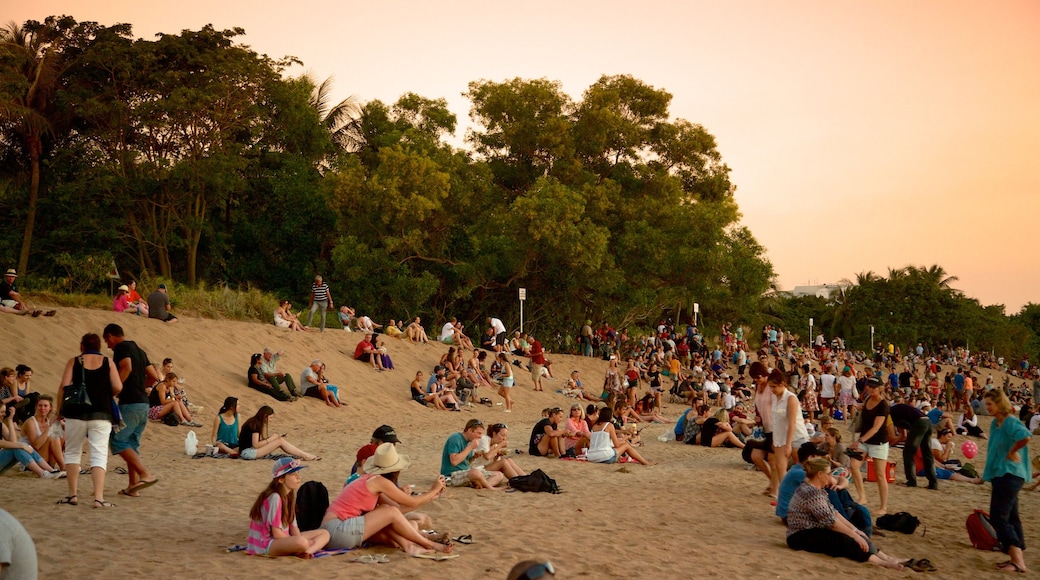 Mindil Beach which includes a sunset and a sandy beach as well as a large group of people