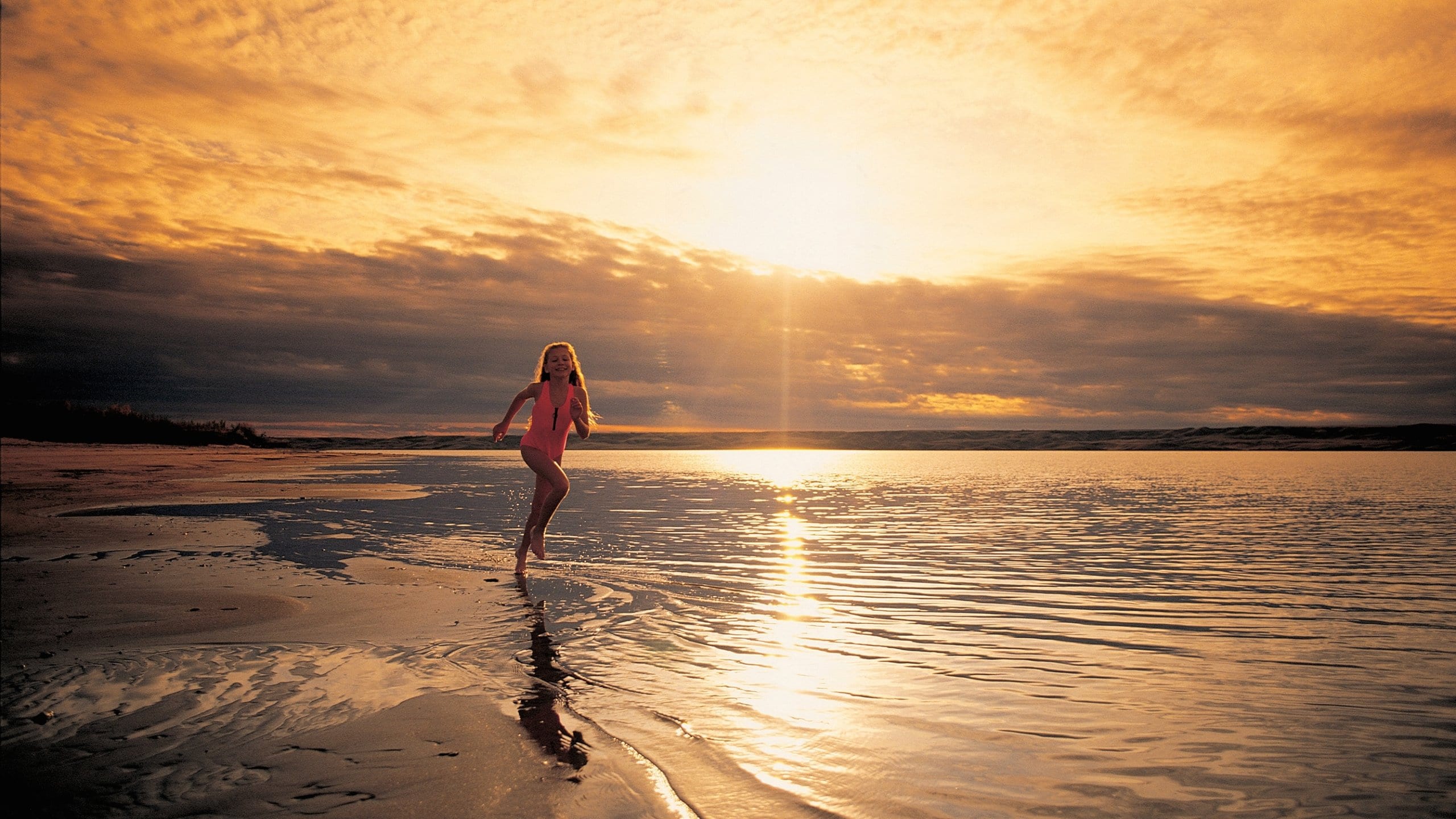 Saskatchewan which includes a sunset and a sandy beach as well as an individual child