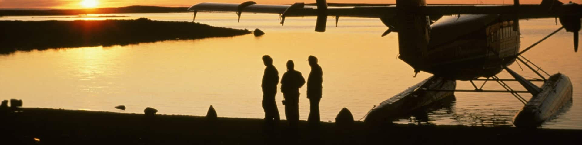 Nunavut featuring a sunset and aircraft as well as a small group of people