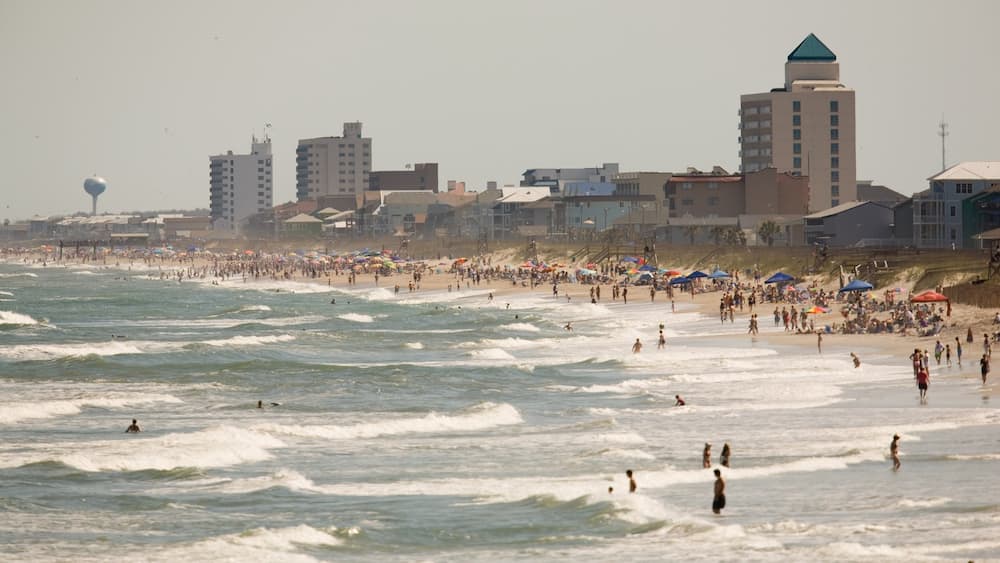 Carolina Beach which includes a coastal town, surf and a sandy beach