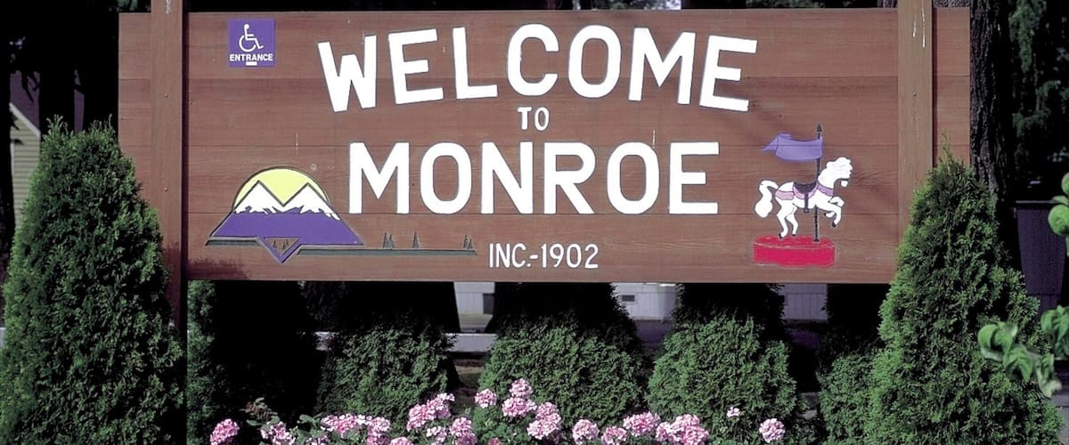 Monroe which includes signage and flowers