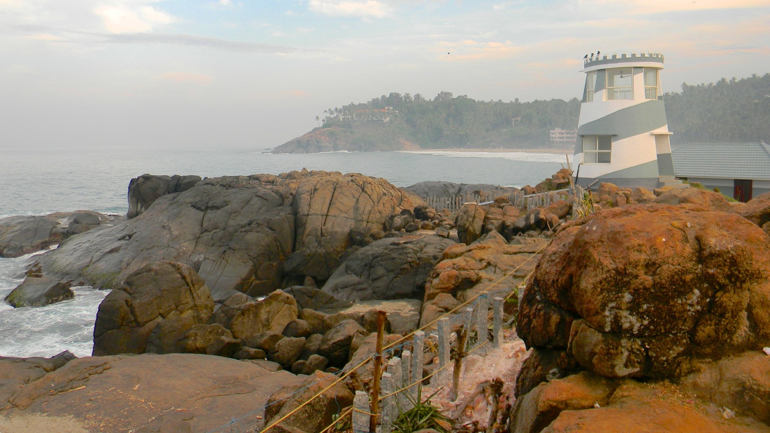 Kovalam ofreciendo costa rocosa y un faro