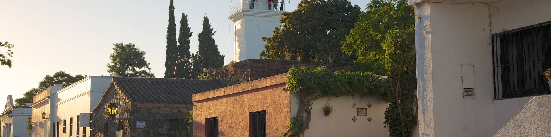 Colonia del Sacramento Lighthouse which includes heritage architecture, a lighthouse and a sunset