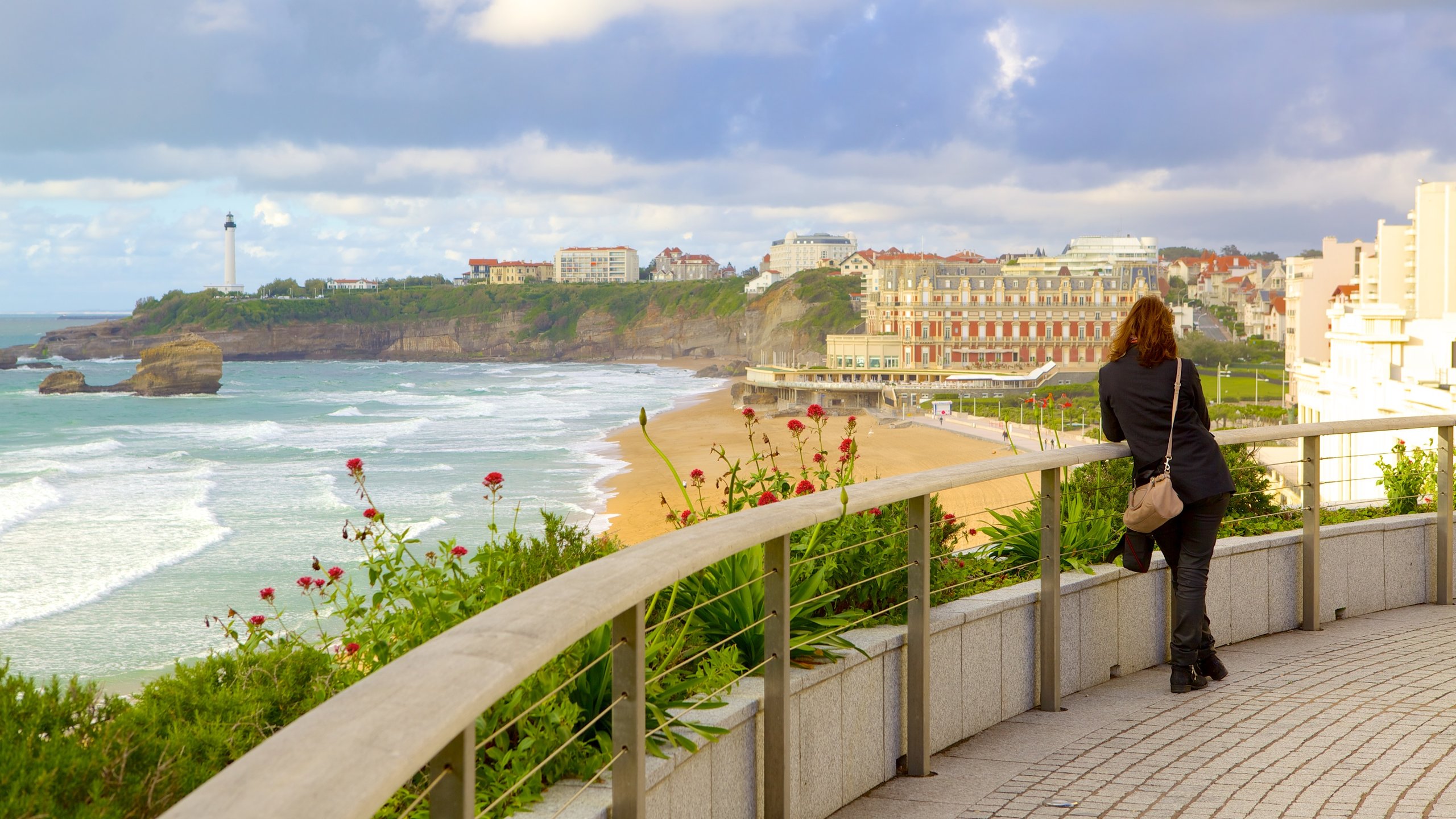 Biarritz which includes views and a coastal town as well as an individual femail