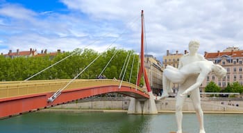 Place Bellecour que inclui um rio ou córrego, uma ponte e uma estátua ou escultura
