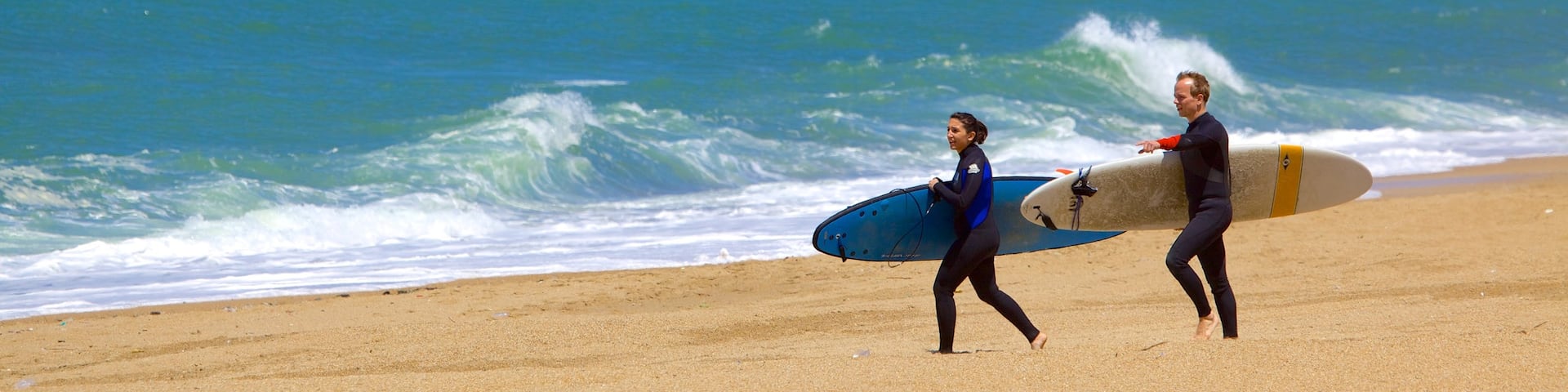 Grand Beach featuring rocky coastline, surfing and a sandy beach