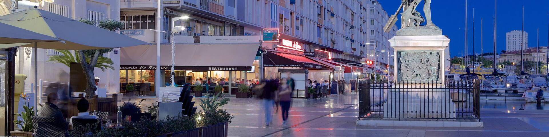 Toulon Marina which includes a square or plaza, night scenes and a statue or sculpture