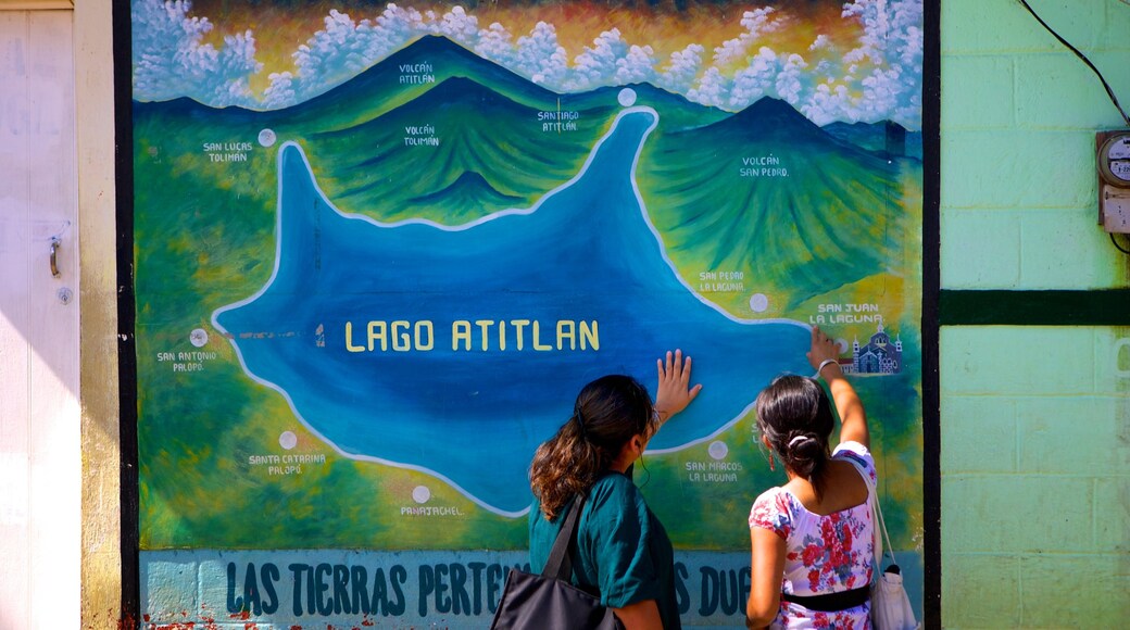 San Juan La Laguna mit einem Beschilderung sowie kleine Menschengruppe