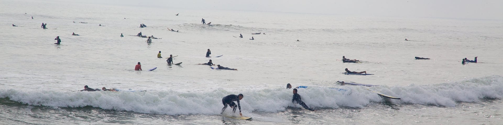 Lima featuring surfing and waves as well as a large group of people