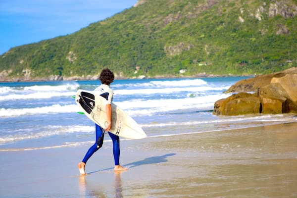 Strand von Matadeiro welches beinhaltet Surfen und Sandstrand sowie einzelner Mann