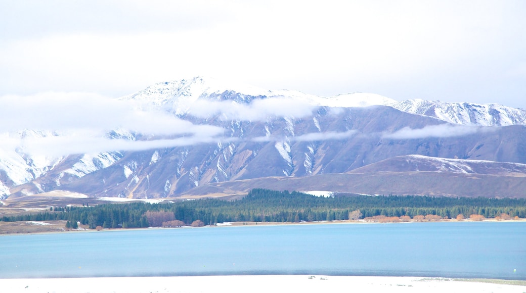 Tekapo Springs presenterar en sjö eller ett vattenhål, snö och berg