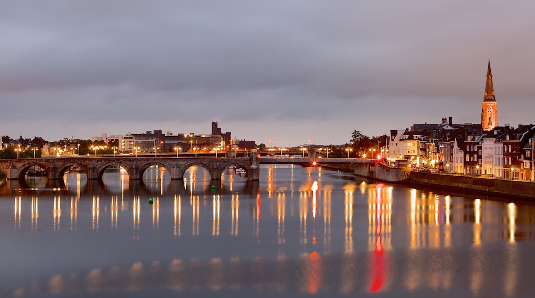 Maastricht showing a river or creek, night scenes and a city