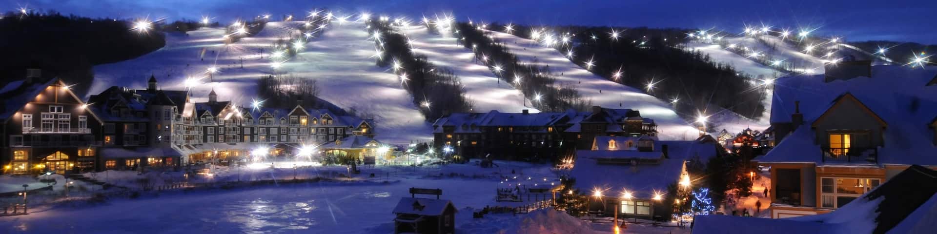 Blue Mountain Ski Resort which includes snow, night scenes and a small town or village