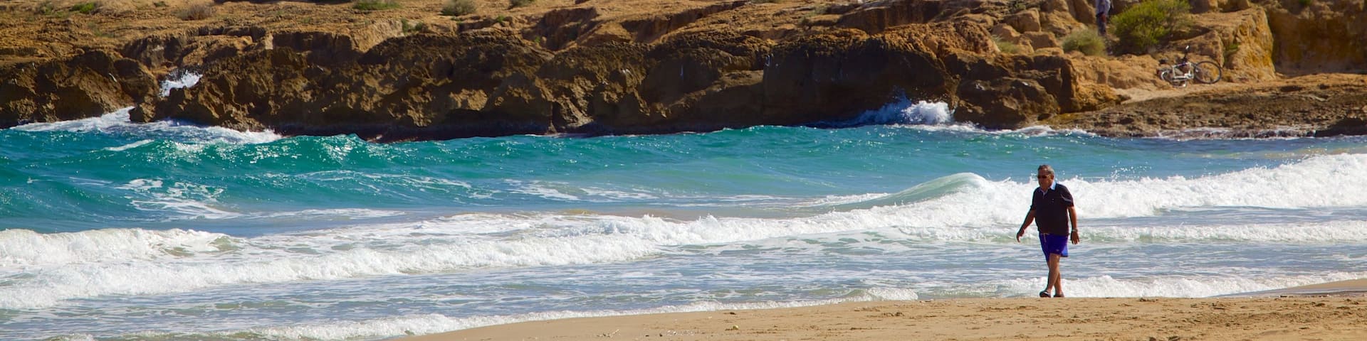 Playa de la Arrabassada ofreciendo costa rocosa, una playa de arena y vistas generales de la costa