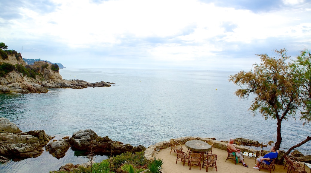 Sant Joan Castle which includes rocky coastline and outdoor eating as well as a small group of people