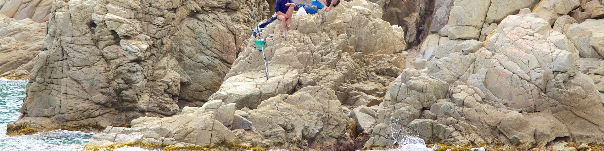 Plage Cala Treumal mettant en vedette vues littorales et côte escarpée aussi bien que petit groupe de personnes