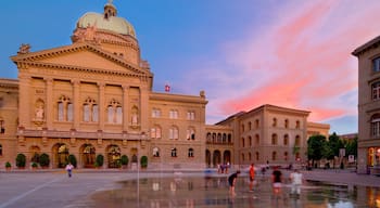 Bundeshaus som inkluderar en solnedgång, historisk arkitektur och ett torg