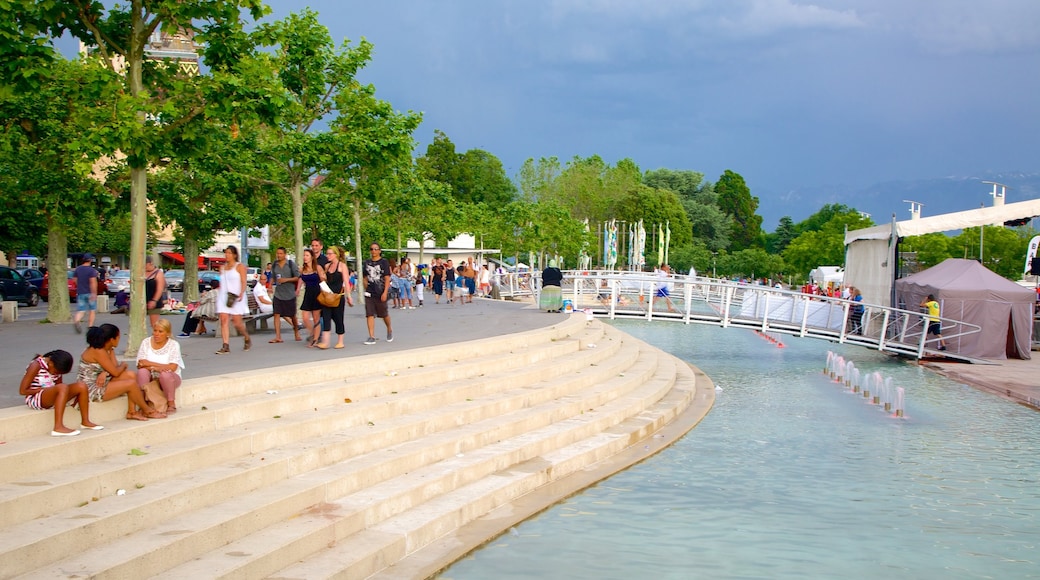 Lausanne showing a square or plaza and a pond as well as a large group of people