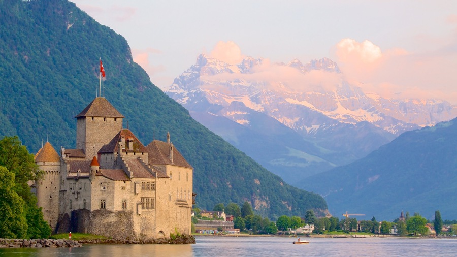 Chateau de Chillon mostrando um lago ou charco, montanhas e um castelo