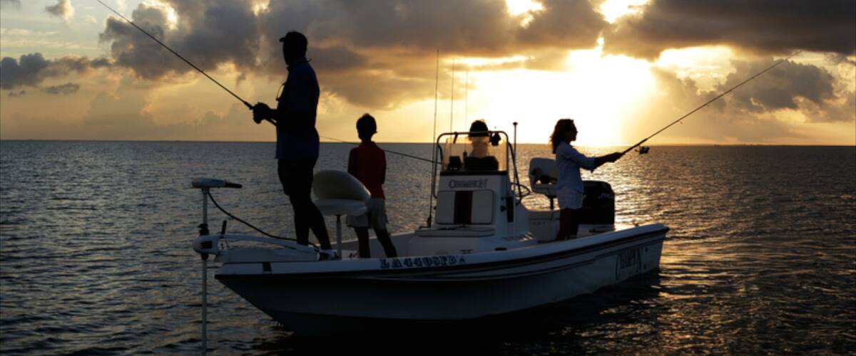 Lake Charles ofreciendo pesca y una puesta de sol y también un pequeño grupo de personas