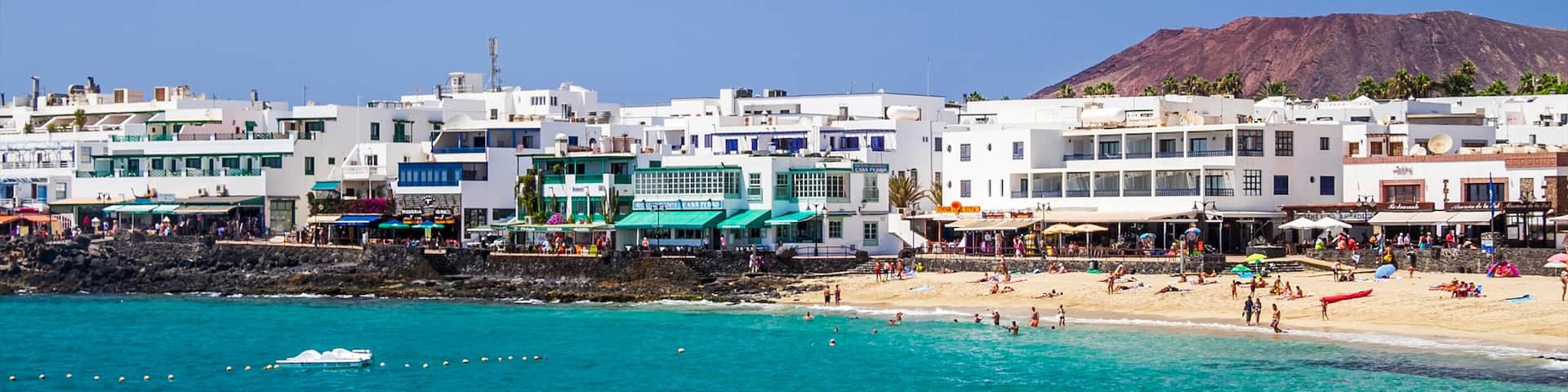 Lanzarote featuring a sandy beach, a luxury hotel or resort and a coastal town