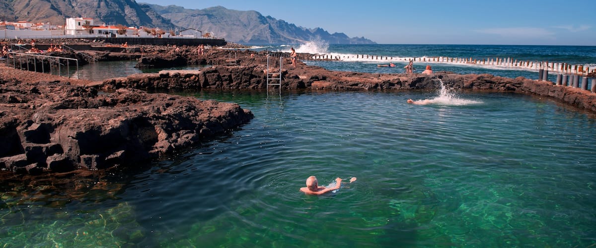 Agaete mostrando costa rocosa y natación y también un hombre