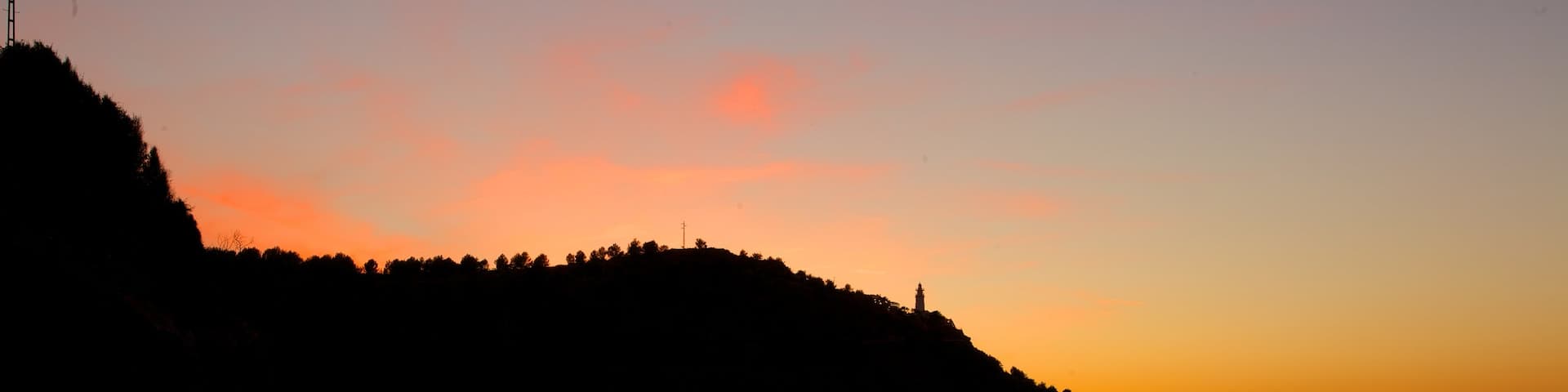 Port de Soller Lighthouse which includes general coastal views and a sunset