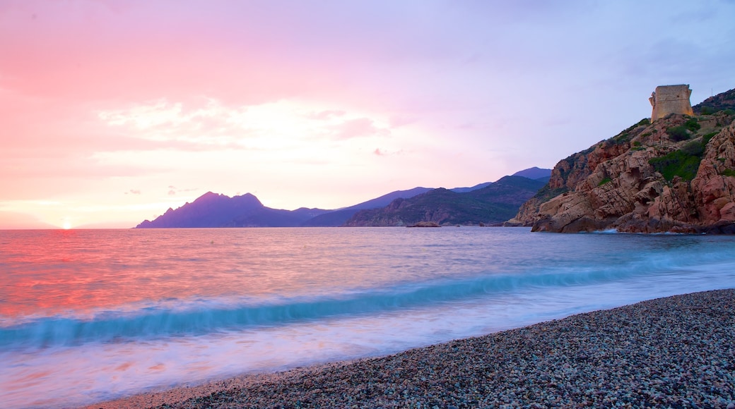 Genoese Tower showing a sunset and a pebble beach