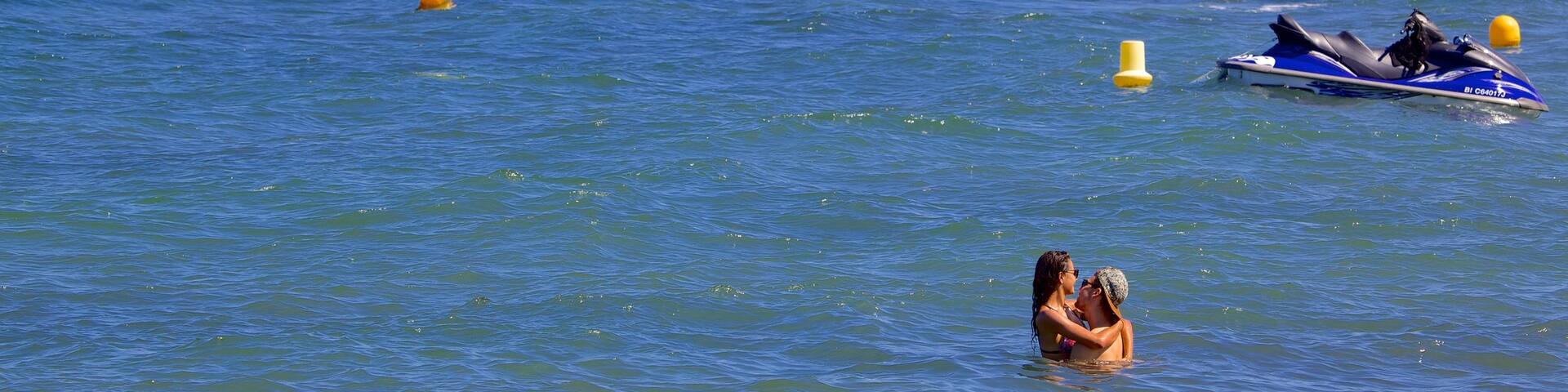 L\'Arinella Beach featuring swimming as well as a couple